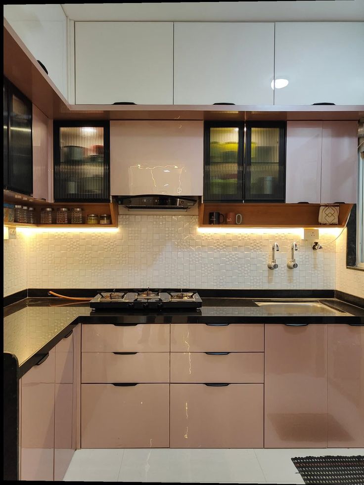 Modern L-shaped acrylic kitchen in soft blush finish with fluted glass cabinets